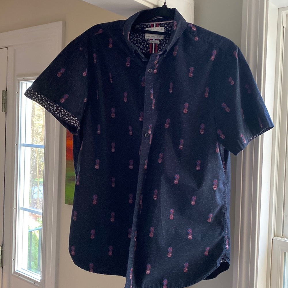 A men’s short sleeved, navy button down shirt. 100% cotton.